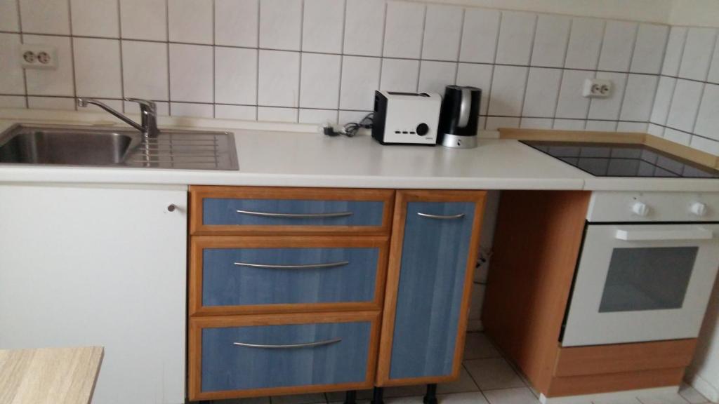 a kitchen with blue drawers and a sink at Natur-Freude-18 in Kotzen