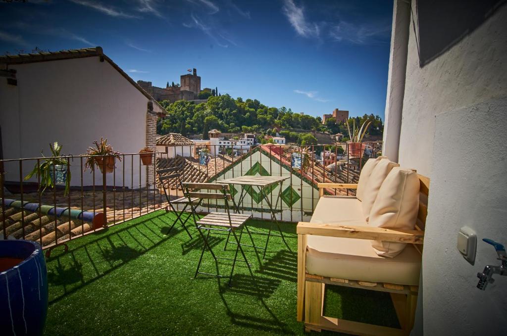 een balkon met stoelen en uitzicht op de stad bij Riad Puertas del Albaicín in Granada