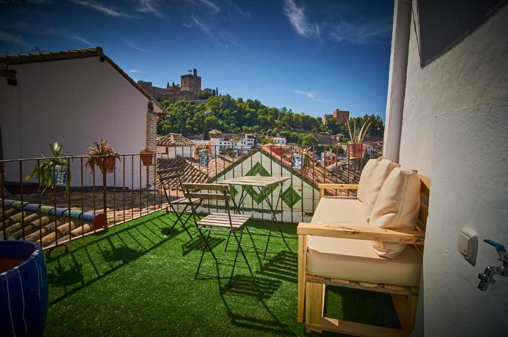 a balcony with chairs and a view of a city at Riad Puertas del Albaicín in Granada
