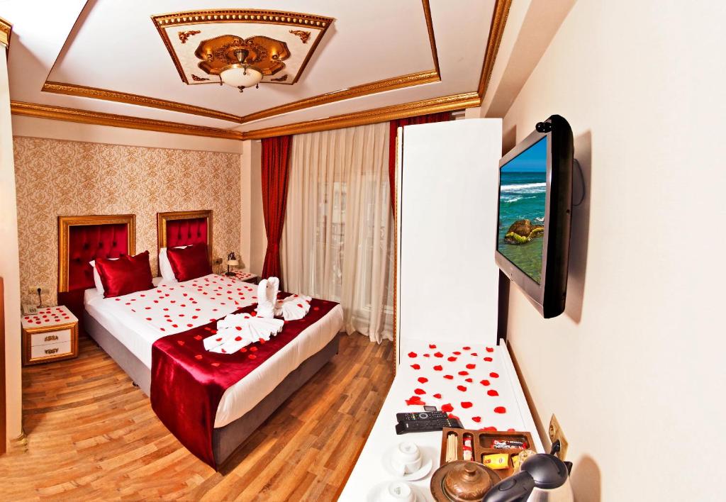 Una habitación de hotel con una cama y un televisor. en Marmara Deluxe Hotel, en Estambul