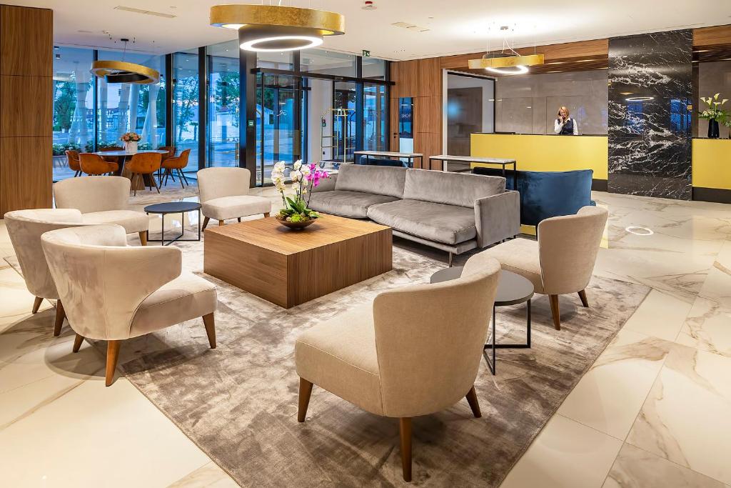 a lobby with a couch and chairs and a table at Luxury Hotel Riva in Malinska