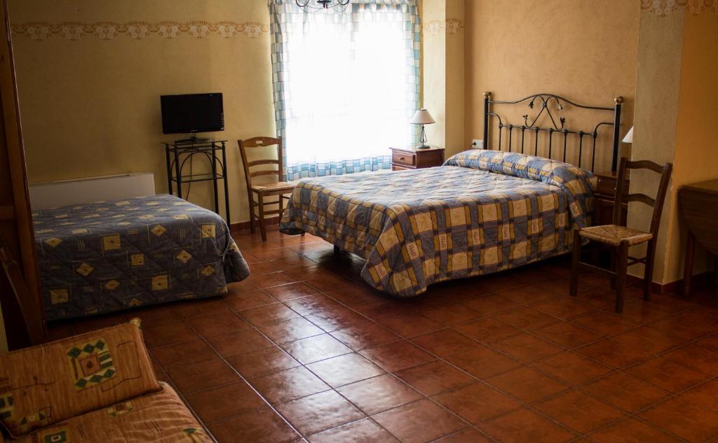 A bed or beds in a room at Pensión Mariola