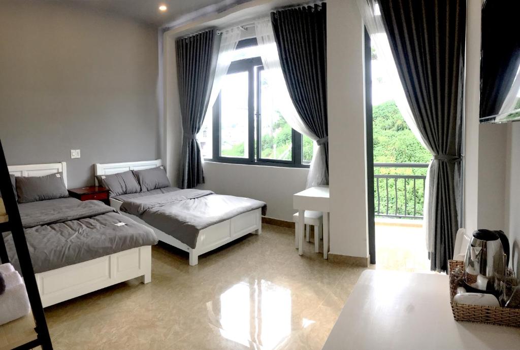 una camera con due letti e una grande finestra di Grey House a Da Lat