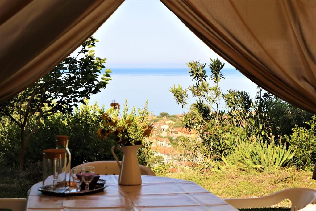 a table in a tent with a view of the ocean at Antico Portale in Ascea