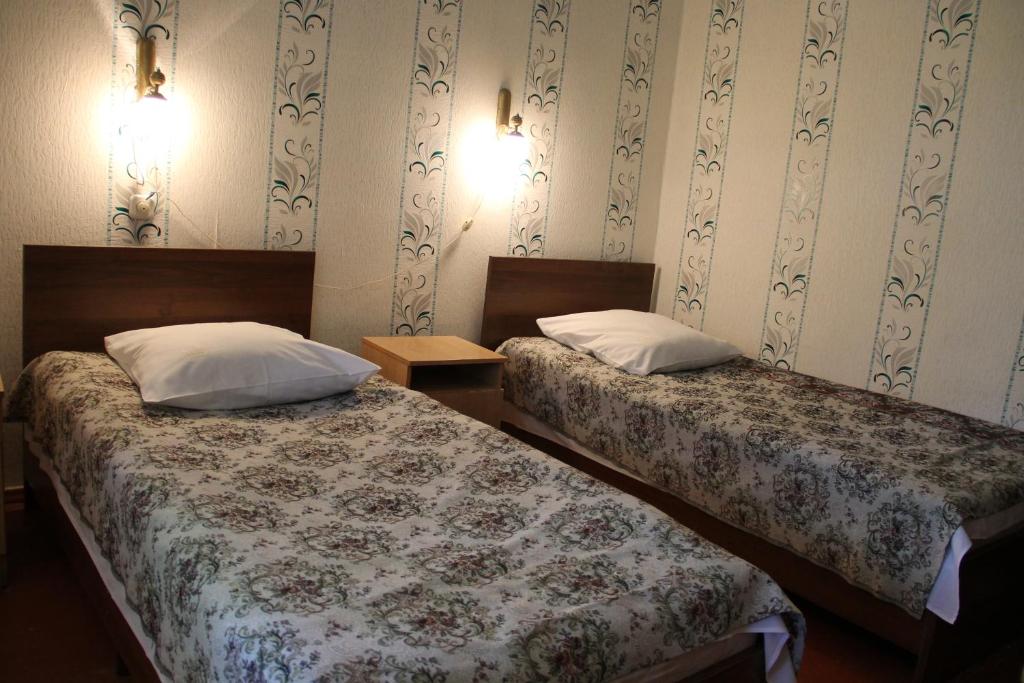 two beds sitting next to each other in a room at Zheleznovodskaya Klinika Sanatorium in Zheleznovodsk
