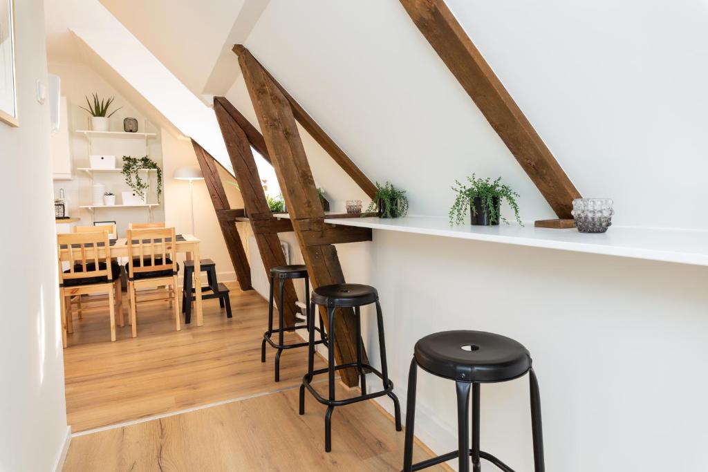 - une cuisine et une salle à manger avec des tables et des tabourets en bois dans l'établissement Alyhr Apartments, à Visby