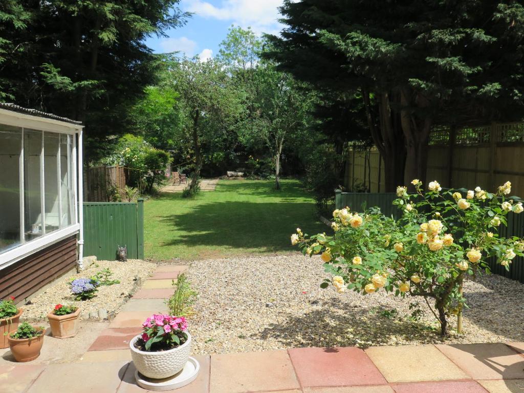 a garden with flowers and a yard with a fence at Garden Flat, Ealing in Ealing