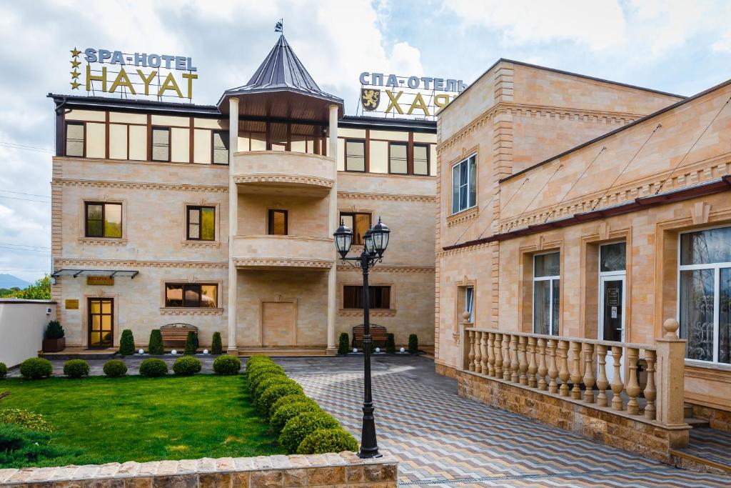 an exterior view of a building with a courtyard at Hayat Spa Hotel in Pyatigorsk