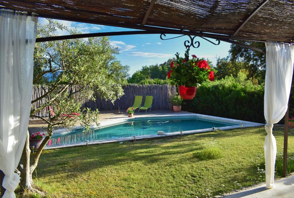 - une piscine dans une cour avec une pergola dans l'établissement Saba, à Cabrières-dʼAvignon
