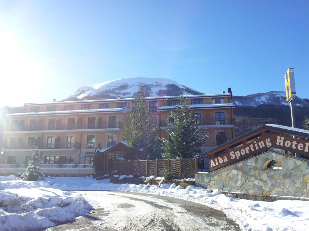 um edifício com um sinal na neve em Alba Sporting Hotel em Rocca di Mezzo