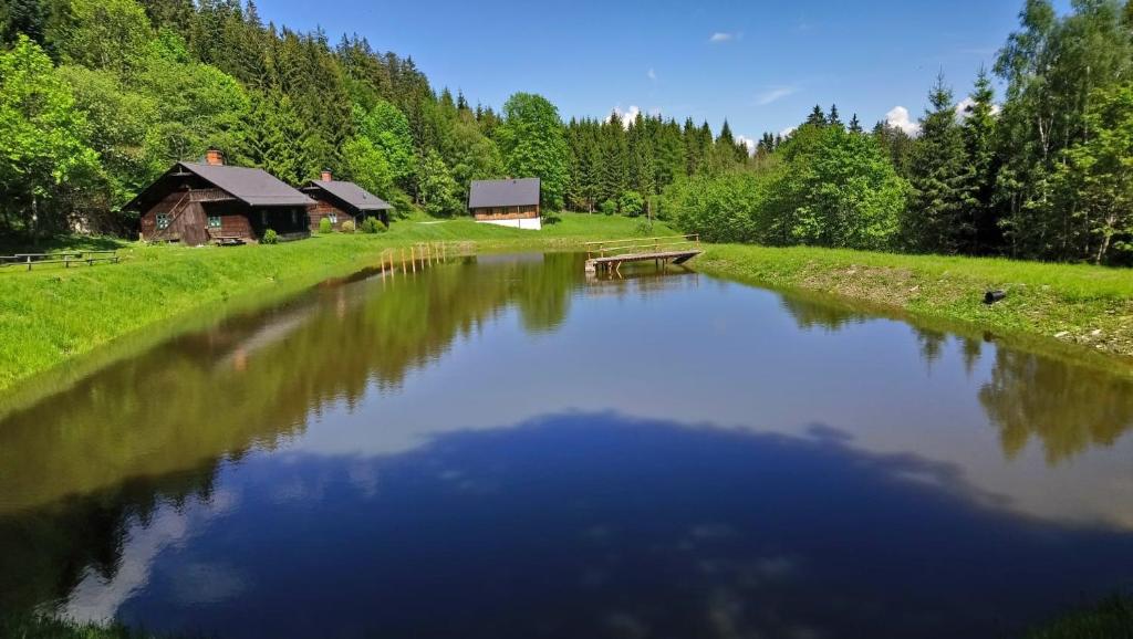 a river with a barn in the middle of a field at Forsthaus Glashütte in Schaueregg