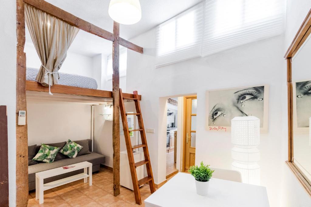 um quarto com um beliche e um sofá em Original loft en Lavapiés em Madrid
