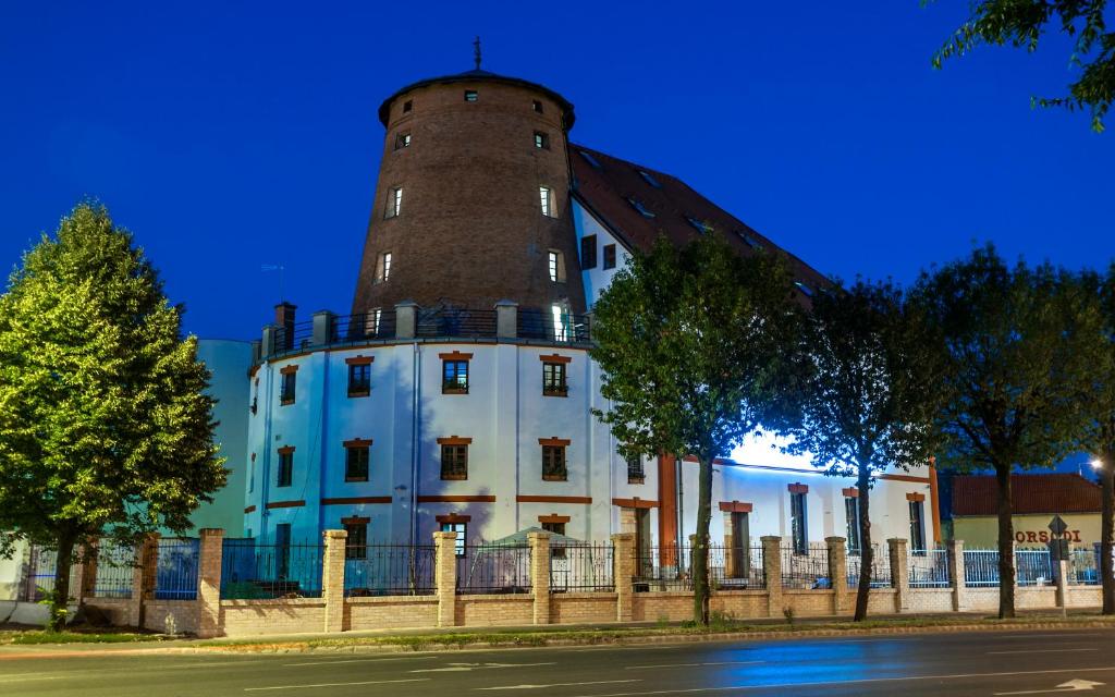 a building with a tower on top of it at Malom Hotel in Debrecen