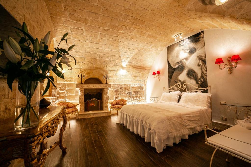 a bedroom with a large bed and a fireplace at L' alcova di Federico in Trani