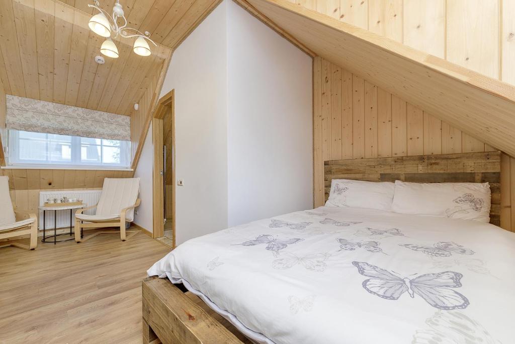 ein Schlafzimmer mit einem Bett in einem Zimmer mit Holzwänden in der Unterkunft Prie Lukos ezero in Trakai