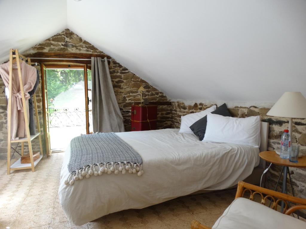 a bedroom with a large bed in a room at Le Grand Guillaume in Saint-Sornin-Lavolps