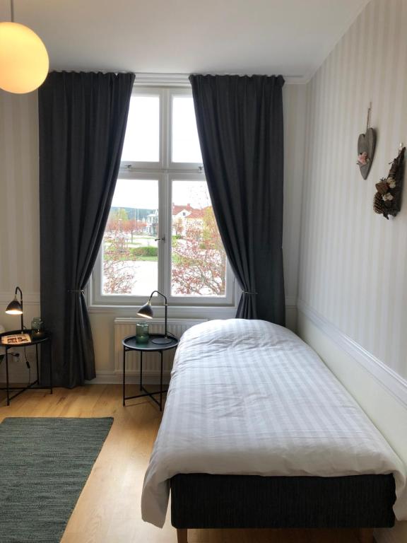 a bedroom with a bed and a large window at Ydre BnB in Österbymo