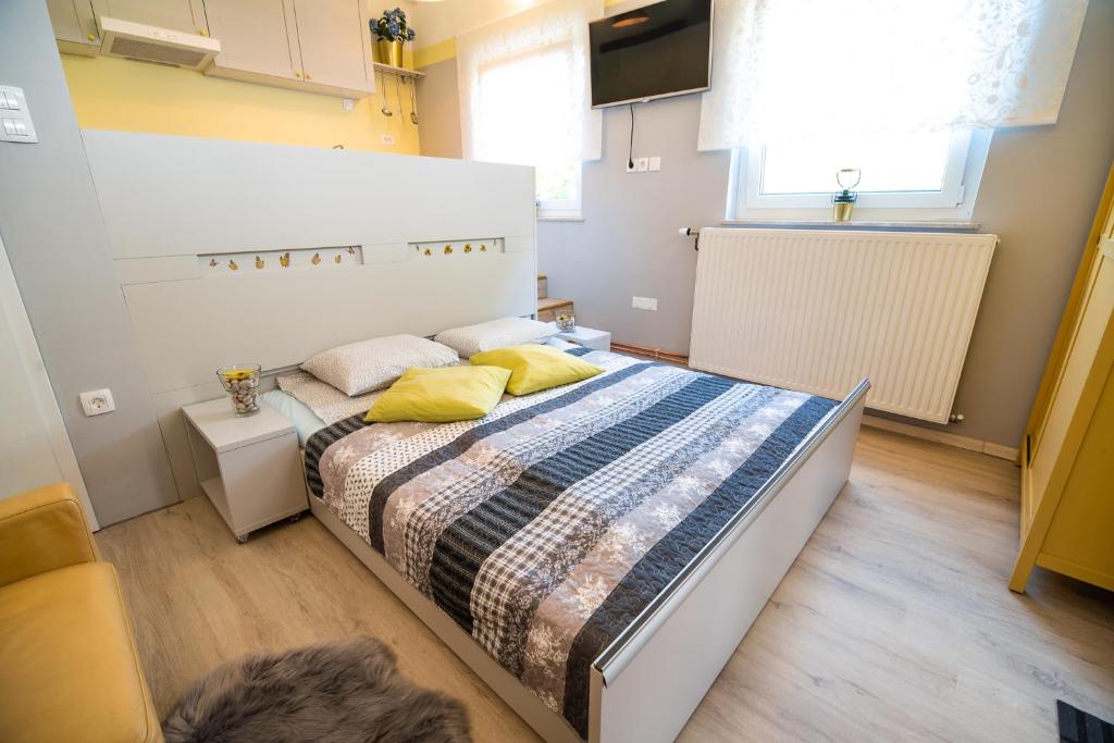 ein Schlafzimmer mit einem großen Bett mit gelben Kissen in der Unterkunft Apartments Stankovo in Krška Vas