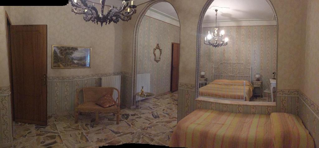 ヴィアグランデにあるIL B&B Maison Graziellaのベッドルーム1室(ベッド2台、鏡、椅子付)