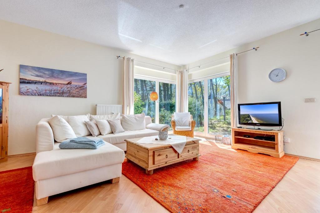 a living room with a white couch and a tv at Haus Berlin Loddiner Höft in Loddin