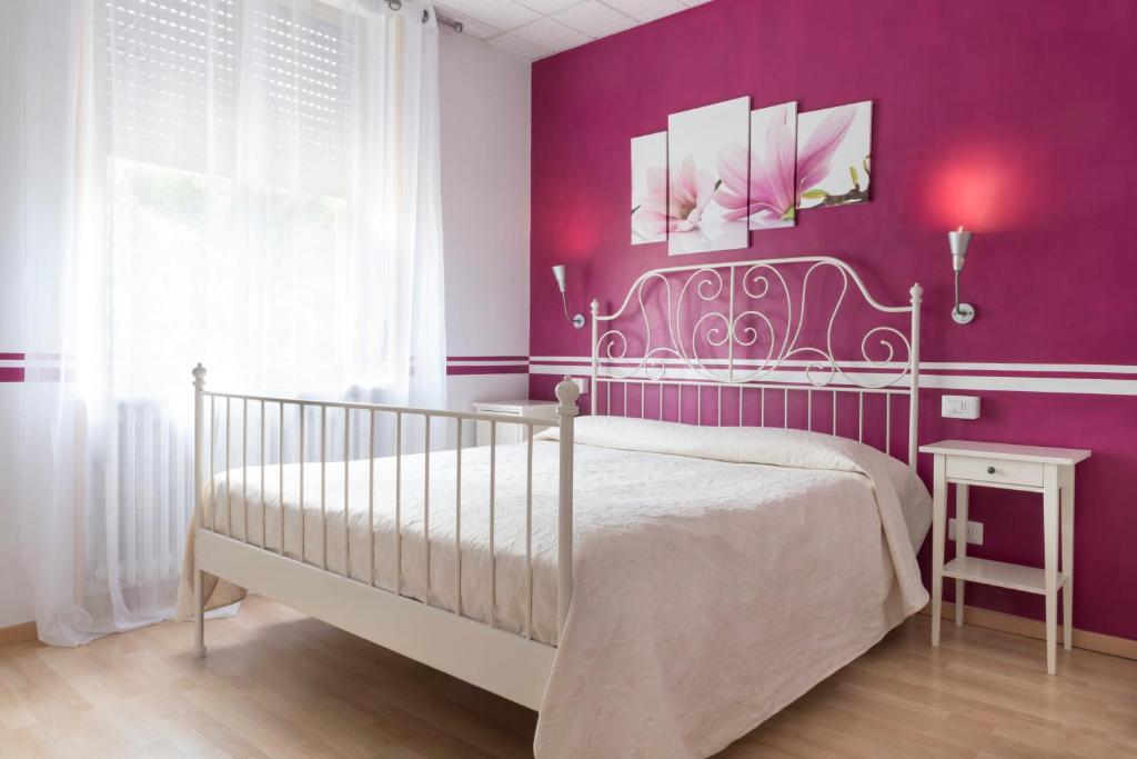 a bedroom with purple walls and a white bed at Le Betulle in San Maurizio dʼOpaglio