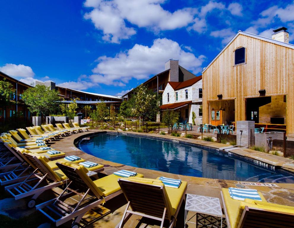 einen Pool mit Liegestühlen und ein Resort in der Unterkunft Lone Star Court, by Valencia Hotel Collection in Austin