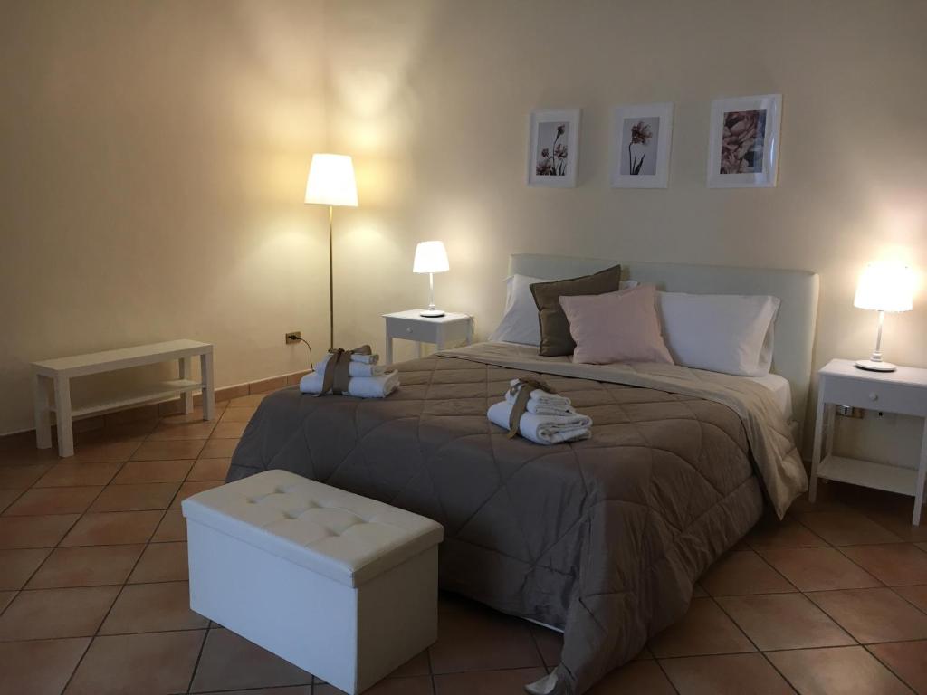 um quarto com uma cama e duas mesas e dois candeeiros em Dolce Vita maison chic em Caserta