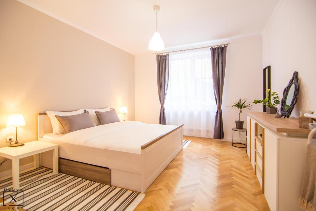 ein Schlafzimmer mit einem weißen Bett und einem Fenster in der Unterkunft Via Del Centro in Sibiu