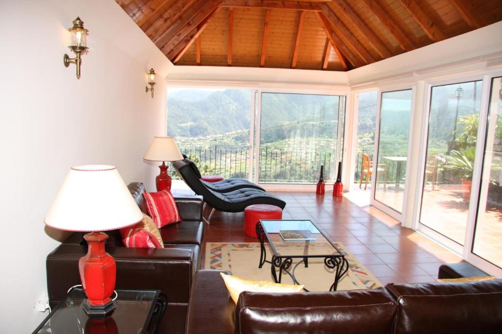 a living room with a couch and a table at Refúgio das Camélias in Santana