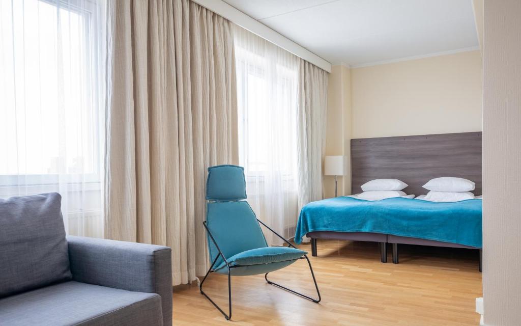 波里的住宿－Torget Aparthotel，一间卧室配有一张床、一把椅子和一张沙发