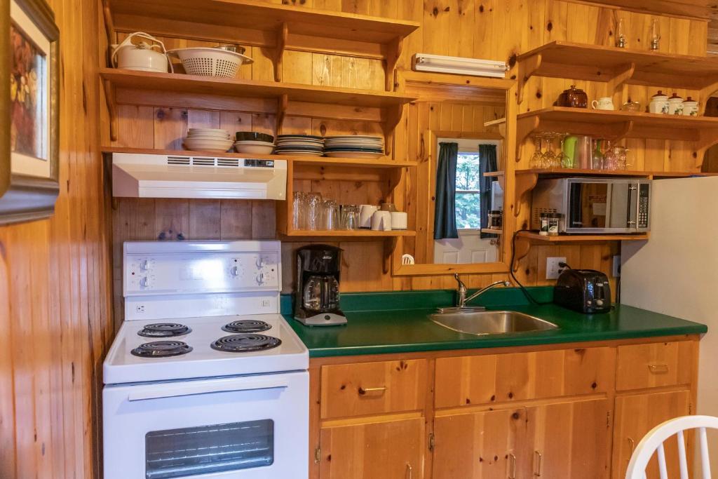 a kitchen with a stove and a sink at Fairways Cottages in Cavendish