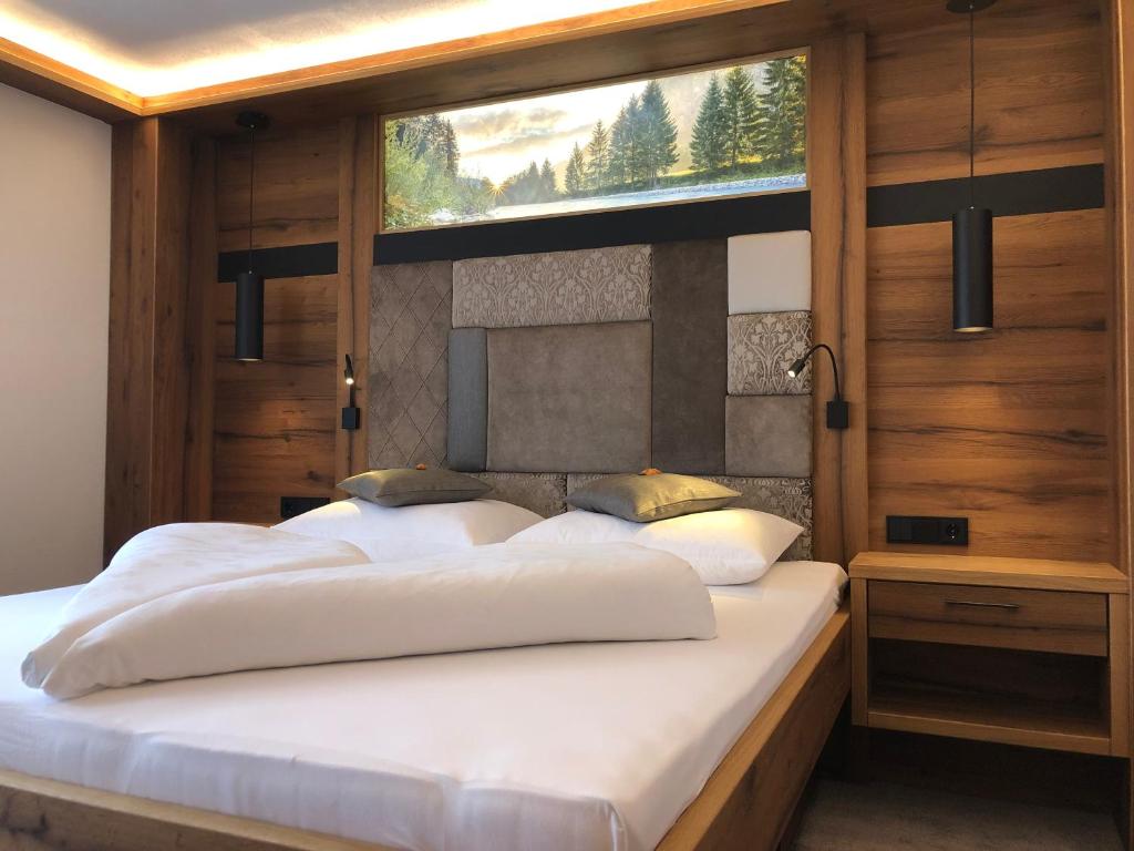 sypialnia z dwoma łóżkami i oknem w obiekcie Pension Alpenperle w mieście Holzgau
