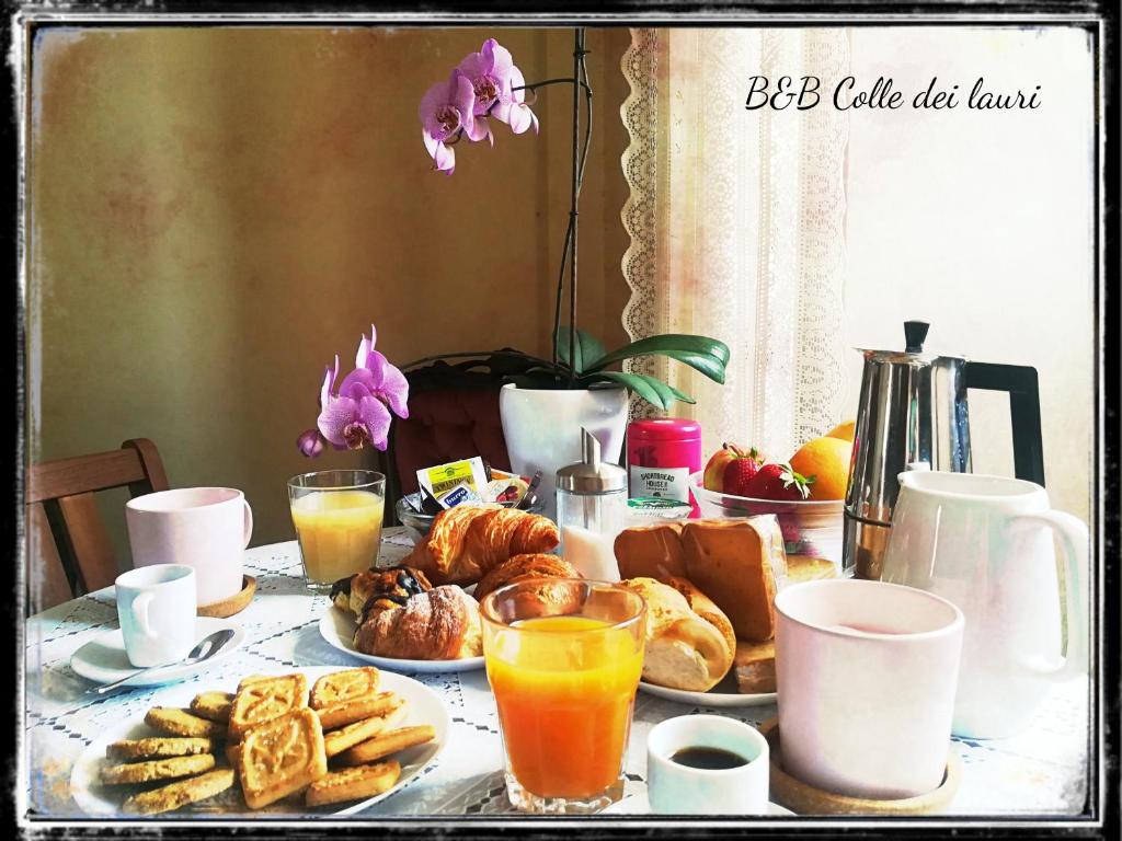 una mesa de desayuno con bollería, naranjas y zumo de naranja en Colle dei lauri, en Loreto