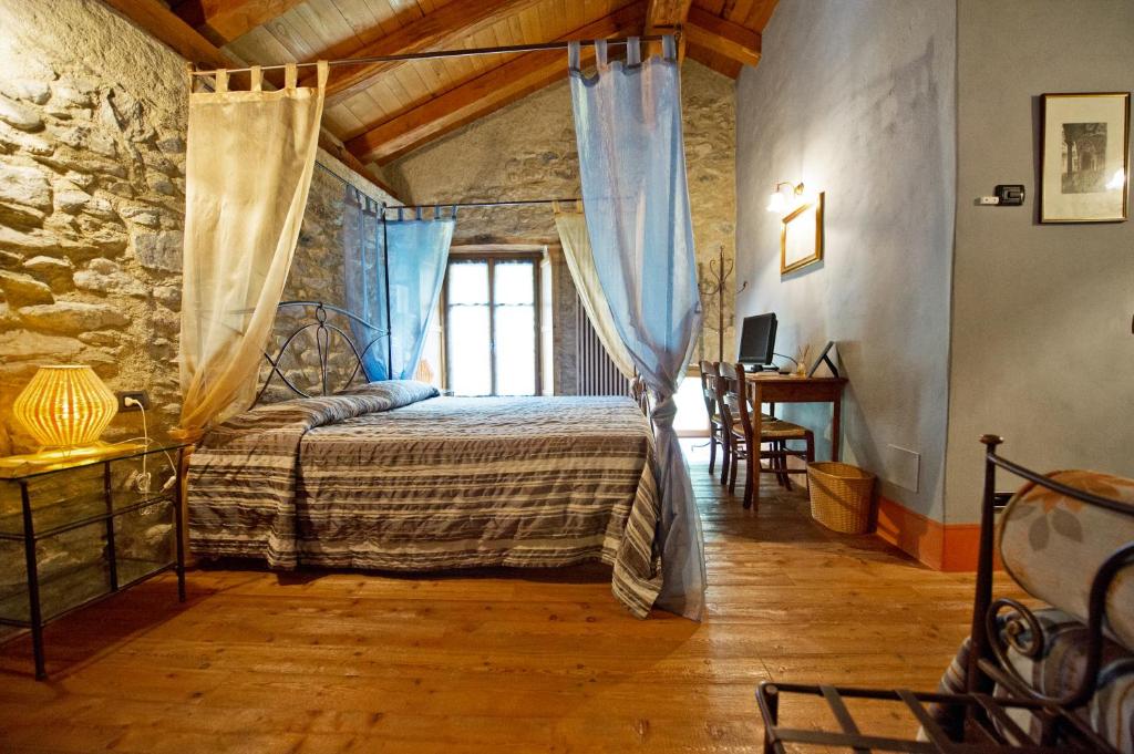 una camera con un letto in una stanza con un muro in pietra di La Maison Des Vignerons Chambres D'Hotes B&B a Donnaz