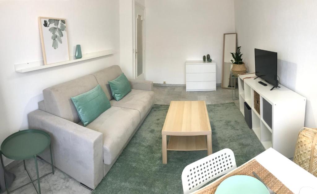 un salon avec un canapé et une table dans l'établissement GREEN STUDIO CANNES CENTRE, à Cannes