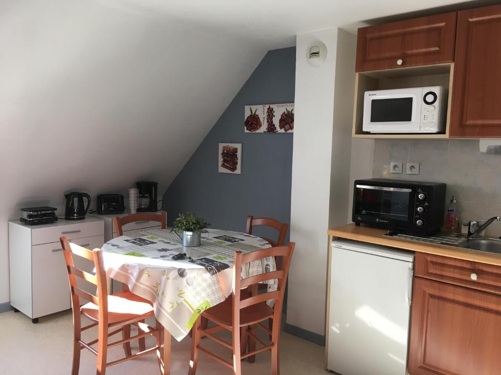 a kitchen with a table with chairs and a microwave at Résidence l'Eterle in Luz-Saint-Sauveur