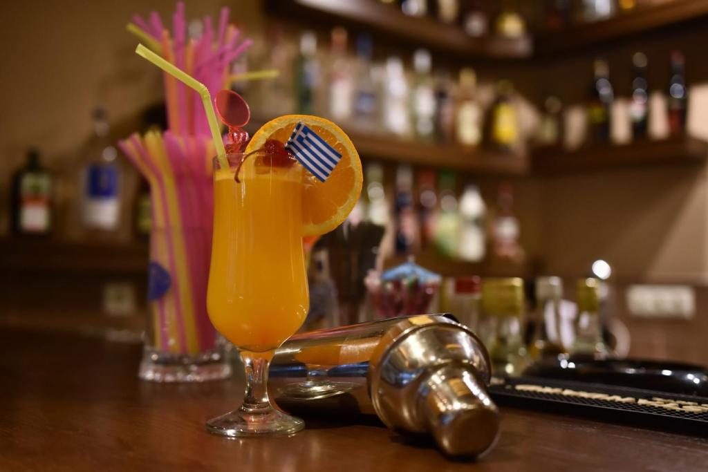 a glass of orange juice sitting on top of a bar at 24 Seven Boutique Hotel in Malia