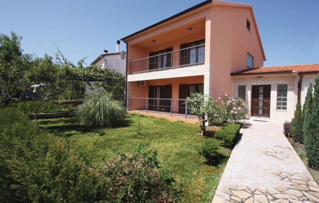 a house with a garden in front of it at Holiday home Elis in Fažana