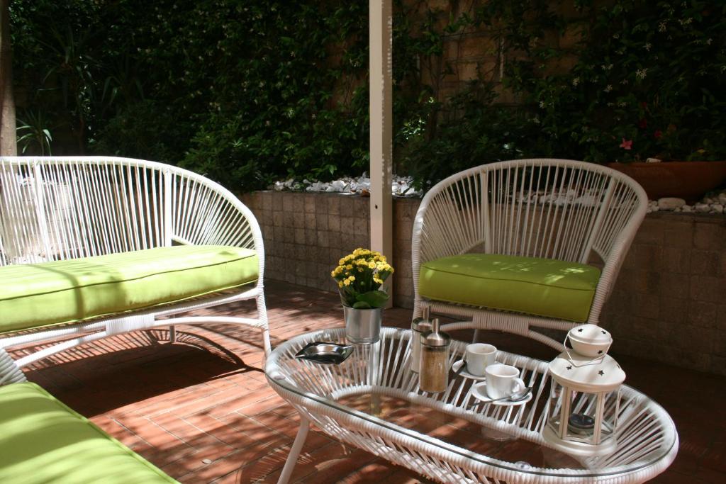 2 rieten stoelen en een tafel met een theeservies op een patio bij St. Peter Garden House in Rome