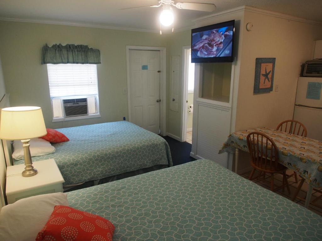 1 dormitorio con 2 camas y TV en la pared en The Catalina, en Panama City Beach