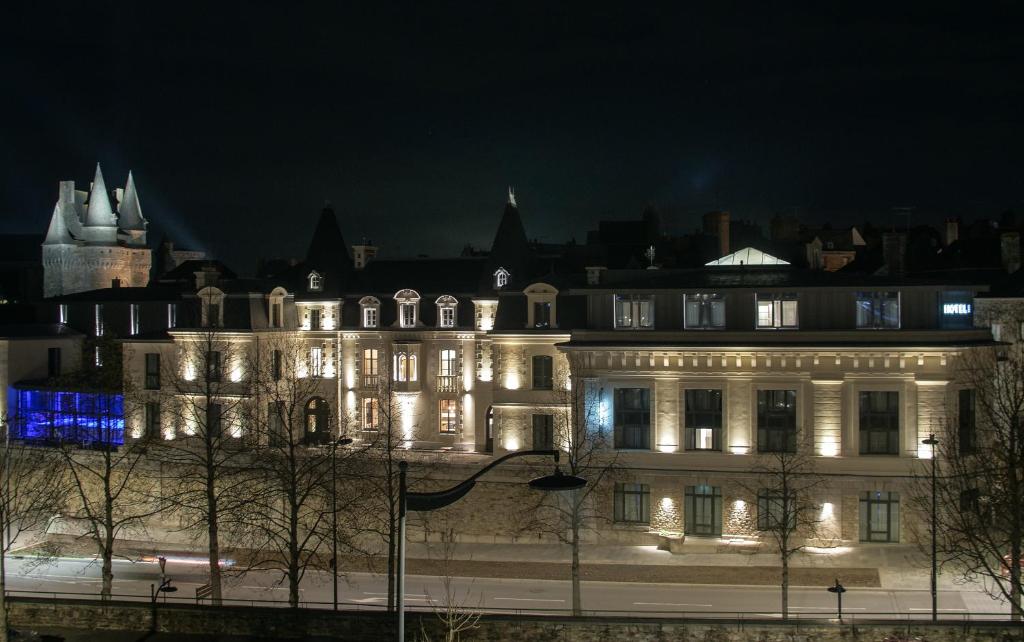 ヴィトレにあるLe Magic Hôtel & Spaの夜にライトが点灯する大きな建物