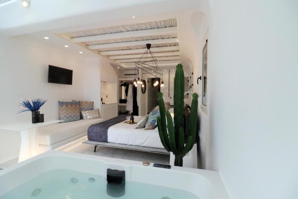 a bathroom with a tub and a bed and a cactus at Narcissus Luxury Suites in Naxos Chora