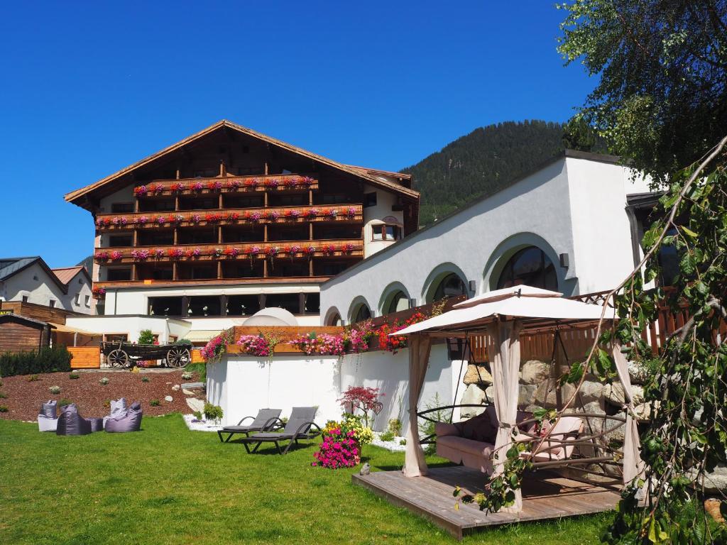duży budynek z mnóstwem krzeseł na dziedzińcu w obiekcie Beauty & Wellness Hotel Tirolerhof w mieście Nauders