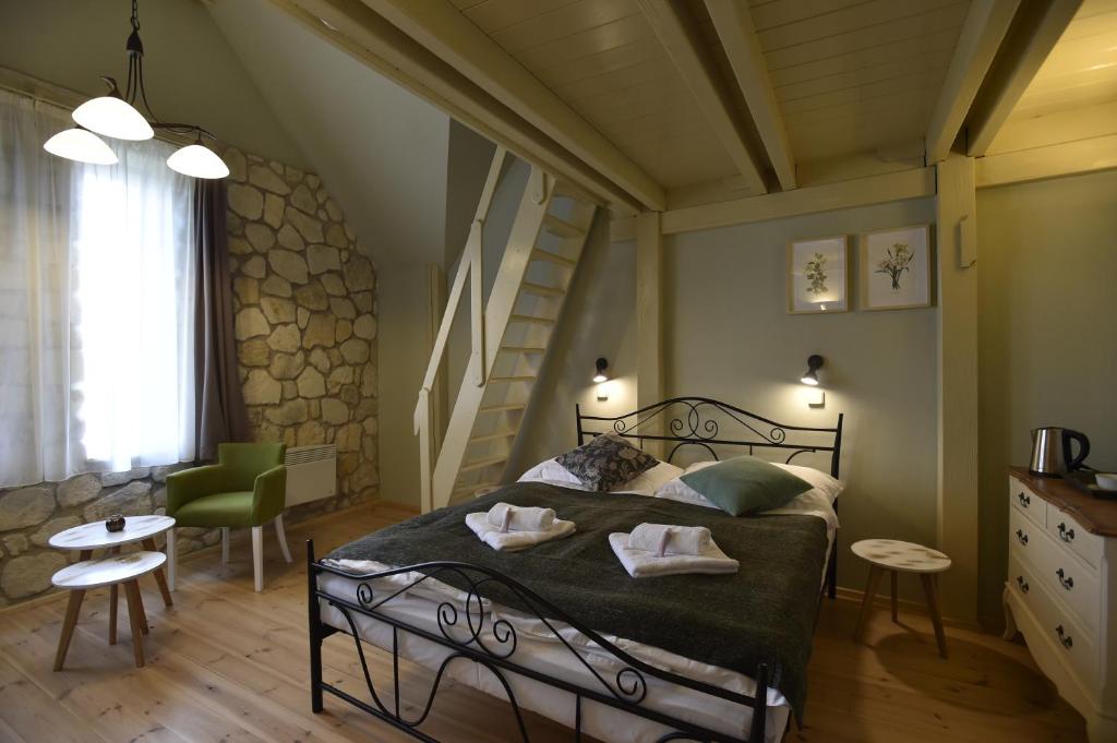 ein Schlafzimmer mit einem Bett mit grüner Bettwäsche und einer Treppe in der Unterkunft Penzion Dobré časy in Valtice