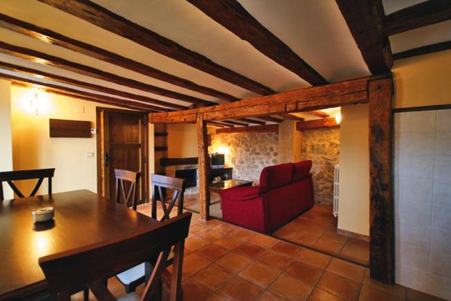 a living room with a table and a red couch at Apartamentos Los Tremedales in Orihuela del Tremedal