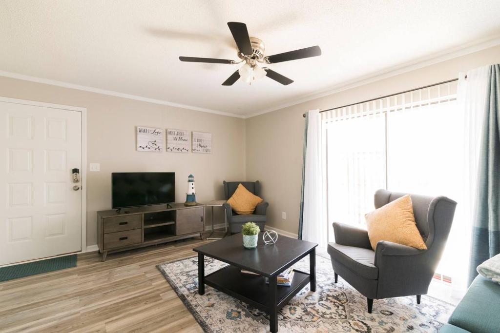 a living room with a ceiling fan and a television at Cute Condo in Rock Hill-57 in Rock Hill