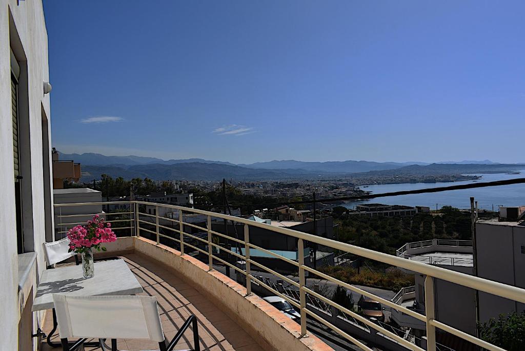 een balkon met een tafel en een vaas met bloemen bij Modern House with Sea View in Chania