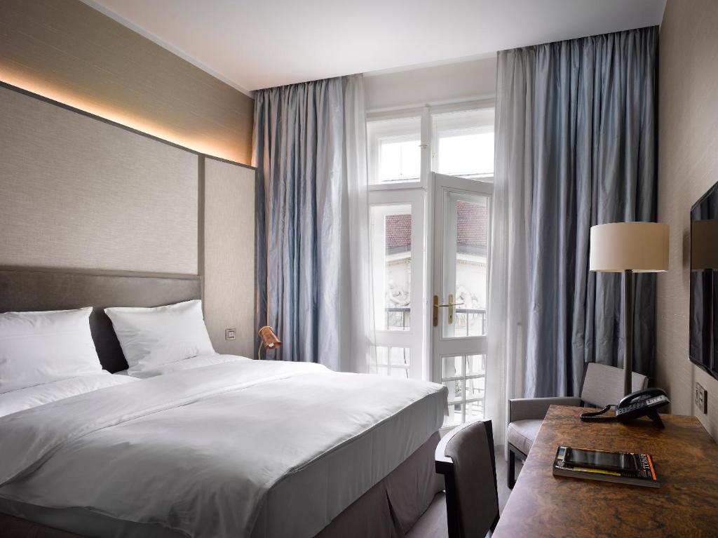 a hotel room with a bed and a window at The Emblem Hotel in Prague