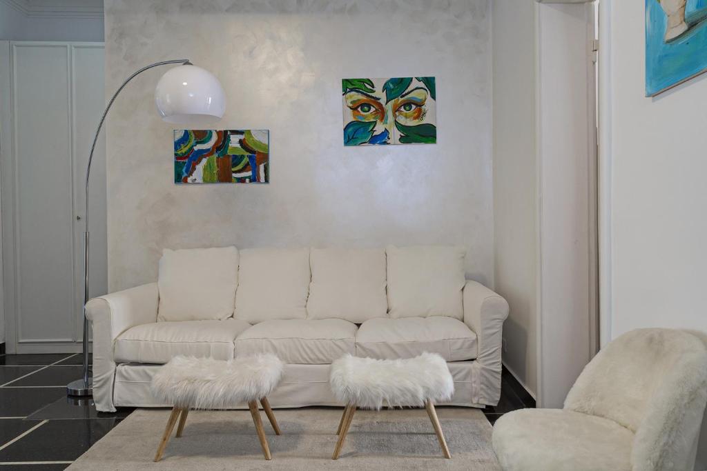 sala de estar con sofá blanco y 2 pinturas en Casa Azzurra by Wonderful Italy, en Génova