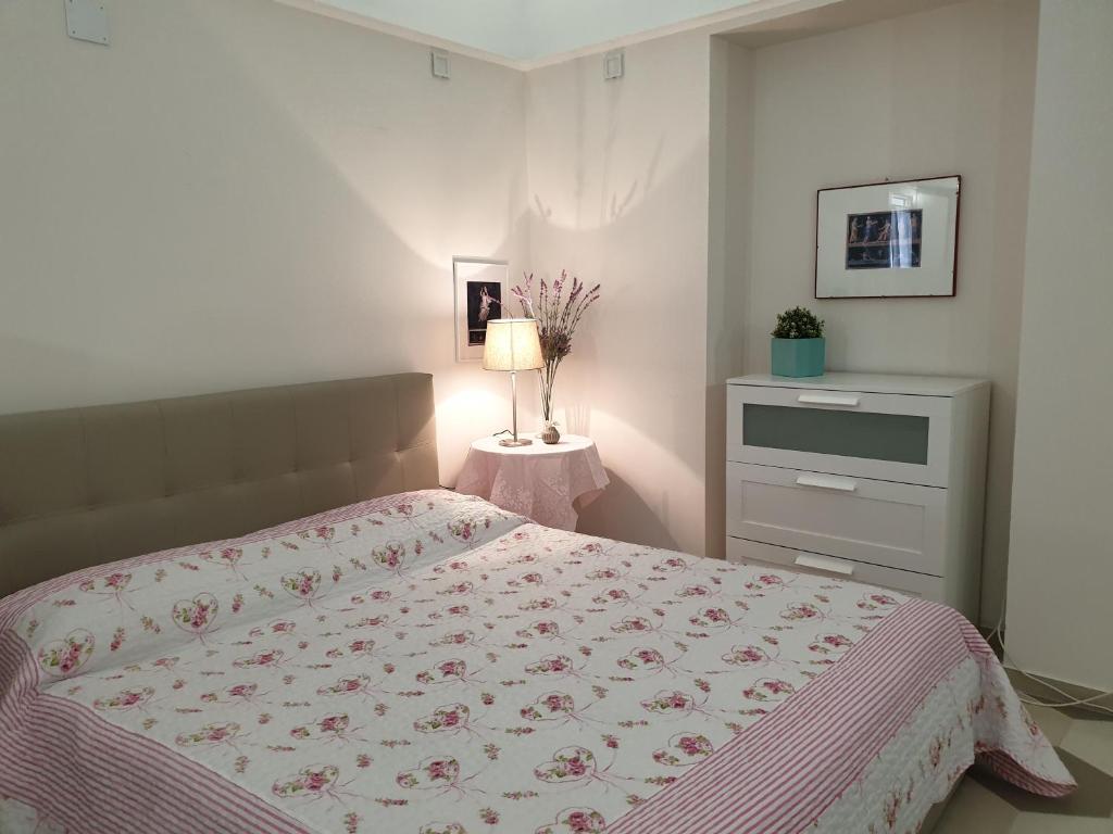 Un dormitorio con una cama y una mesa con una lámpara. en Pompeii my life, en Pompeya